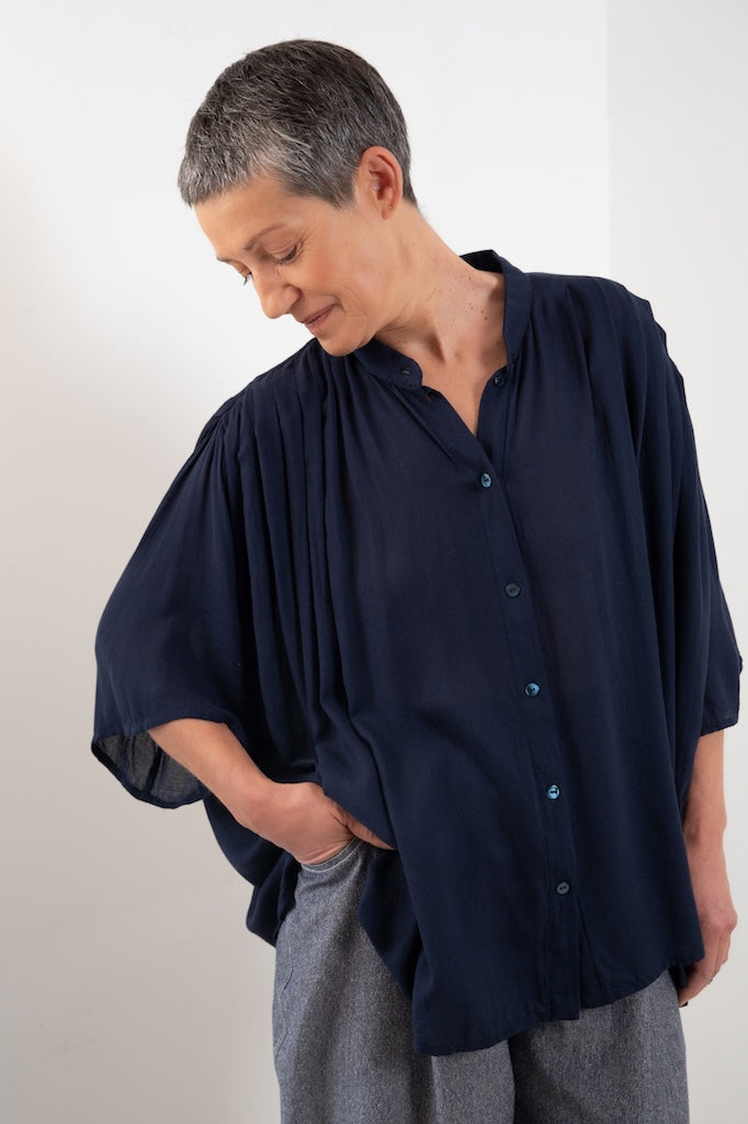 Blouse Marion bleue plissée portée – silhouette oversize, col officier, Made in France, tissu bleu nuit fluide issu de stock dormant, boutons nacres - Onarch