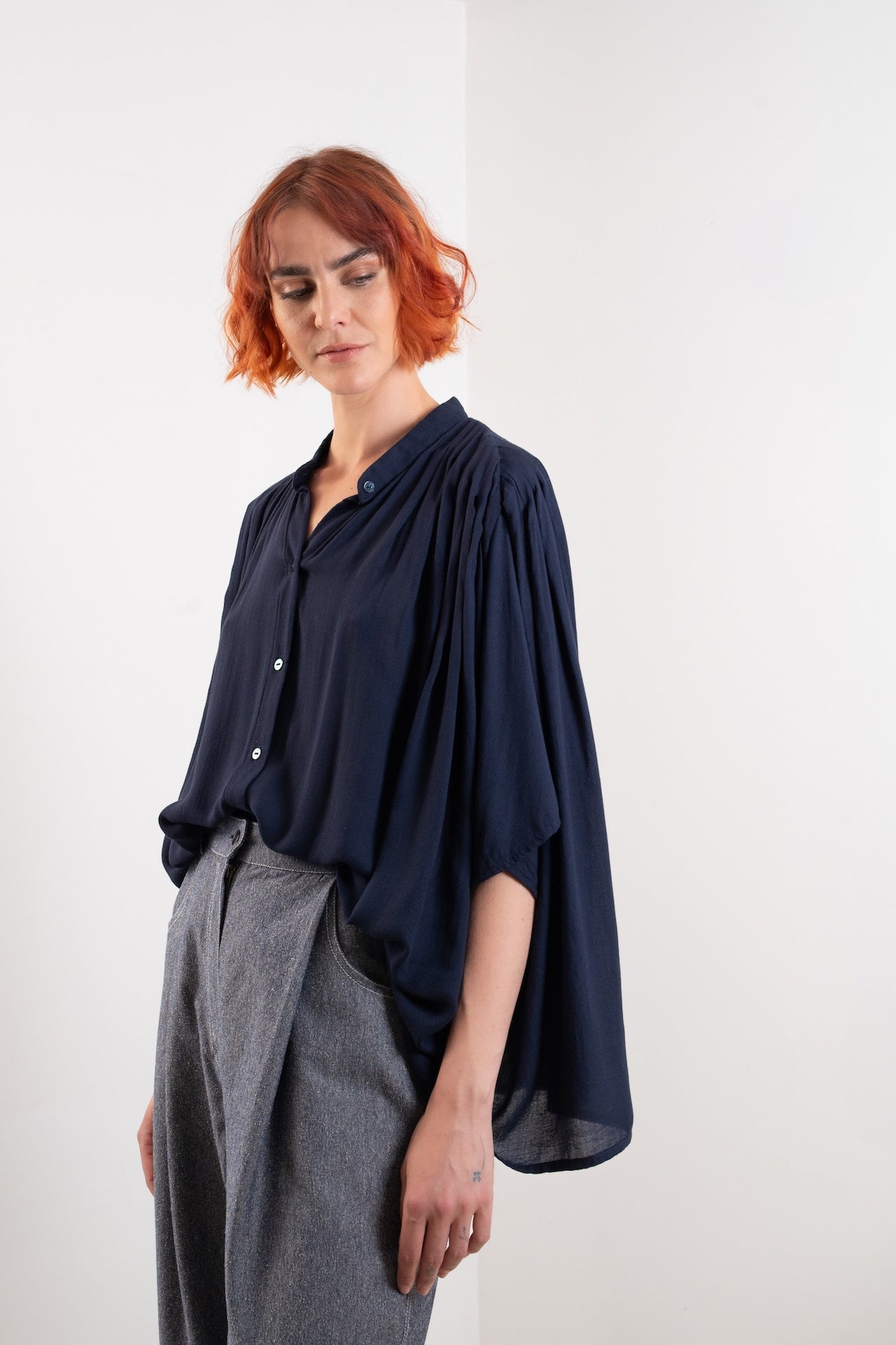 Blouse Marion bleue plissée – vue trois quarts rentrée, coupe oversize, col officier, boutons nacres, Made in France, tissu bleu nuit fluide issu de stock dormant - Onarch