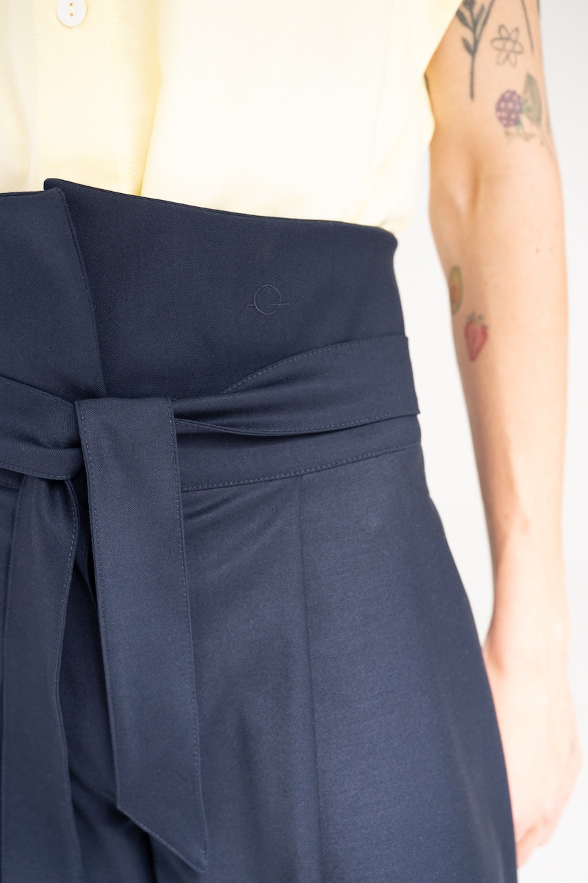 Pantalon jupe culotte à plis taille haute relevée et poches coutures côtés bleu marine – vue détails broderie ceinture et ceinture nouée – Onarch