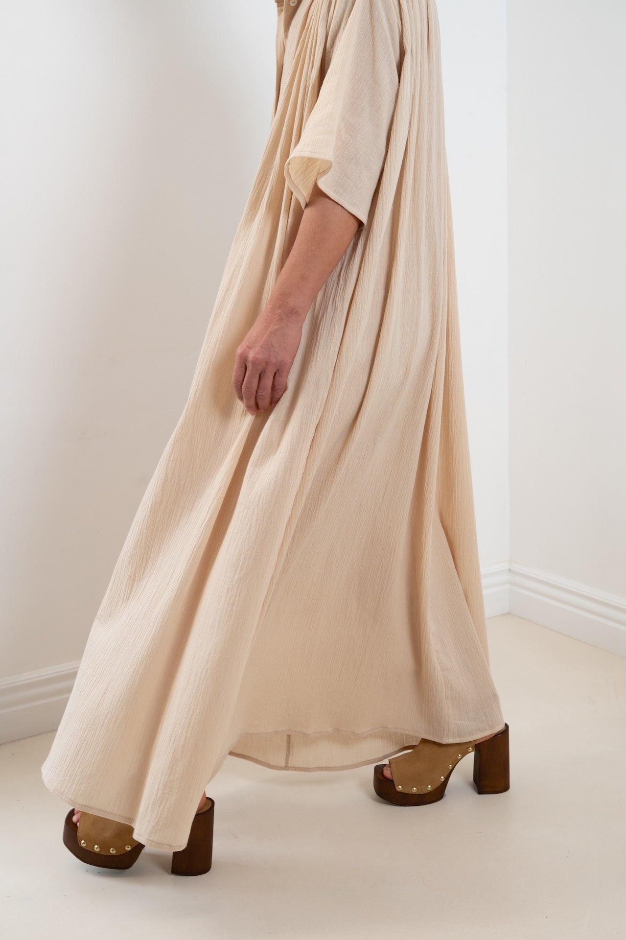Maxi dress Robe Marine plissée oversize  couleur sable 100% coton, col officier, en mouvement, vue de profil bas – Onarch
