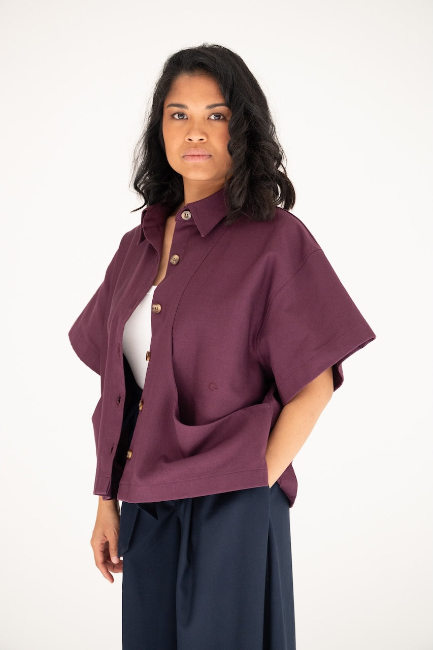 Surchemise Christine ouverte en gabardine coton pourpre carrure large manches courtes surpiqûres broderie – vue 3/4 poches arrondies boutons cornes marrons – Onarch